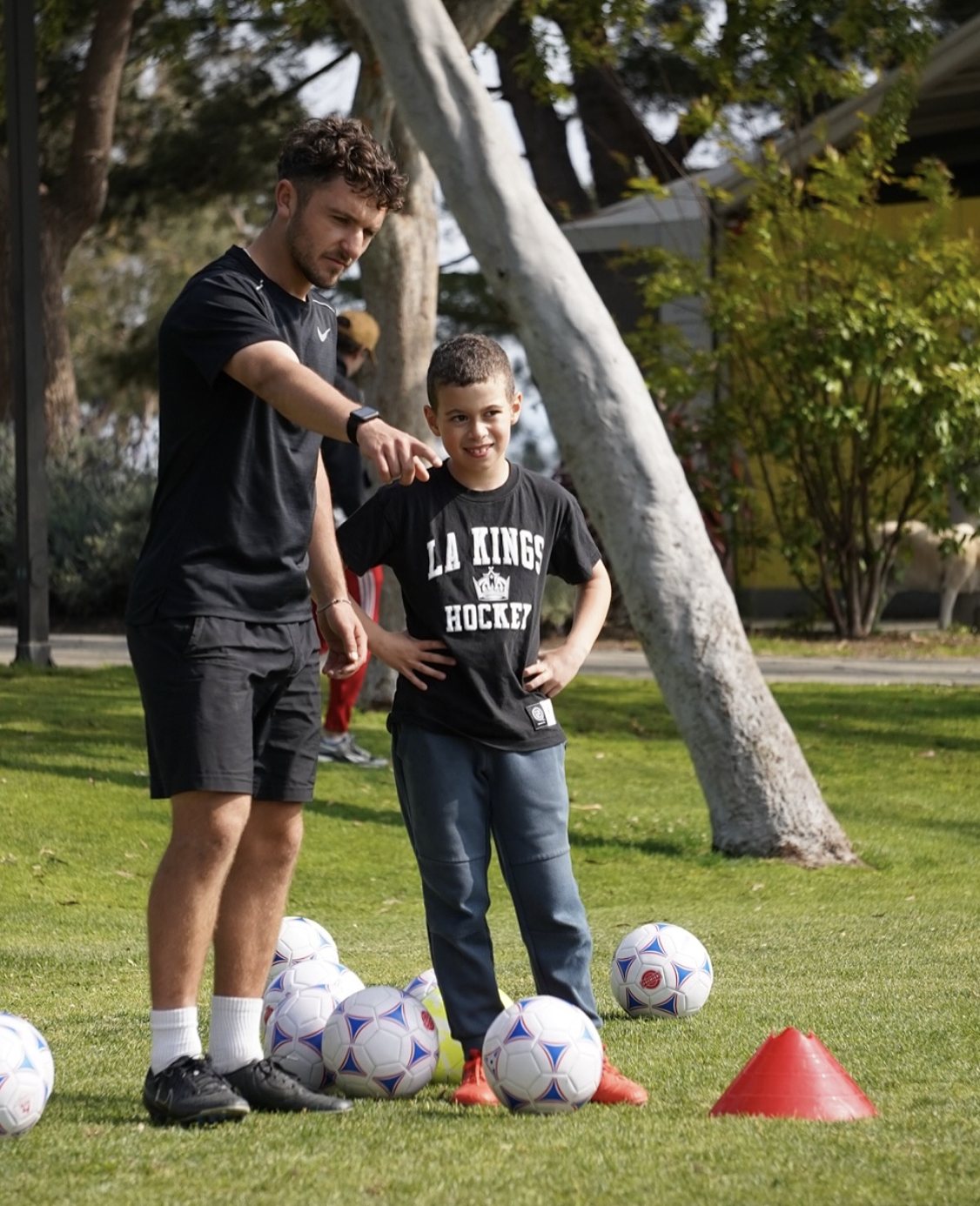 Coach Liam Chawke giving a young player one-on-one instruction