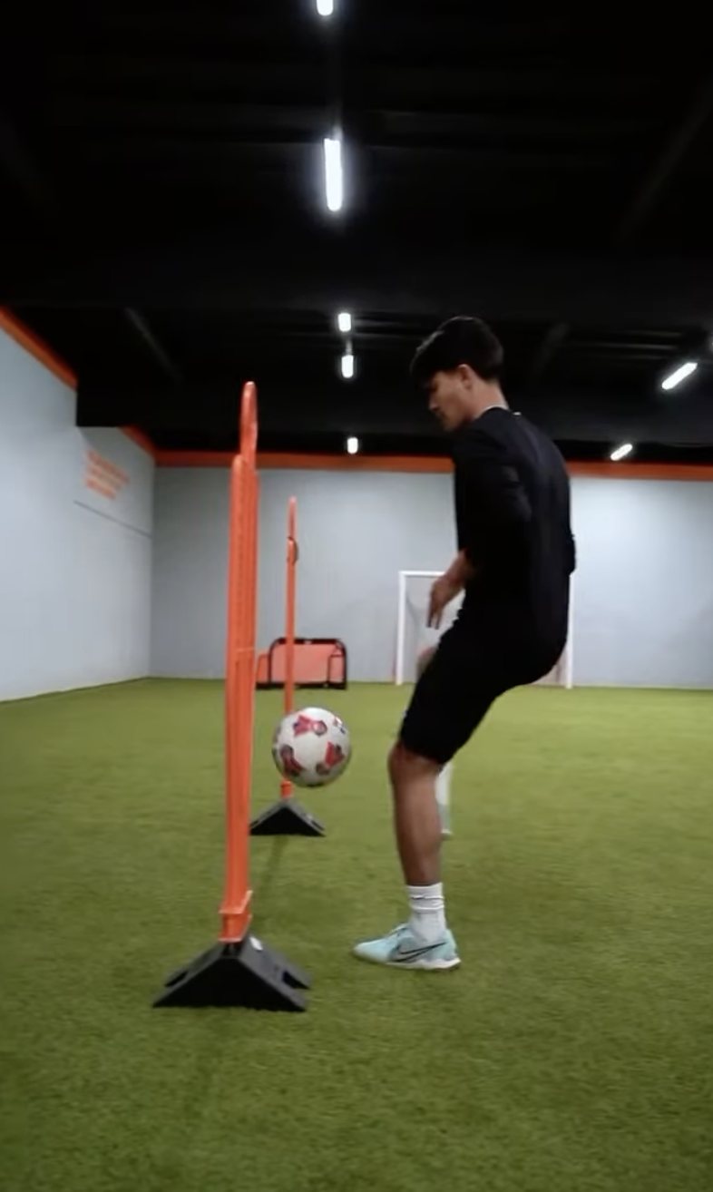 Player working on close control around poles at indoor training