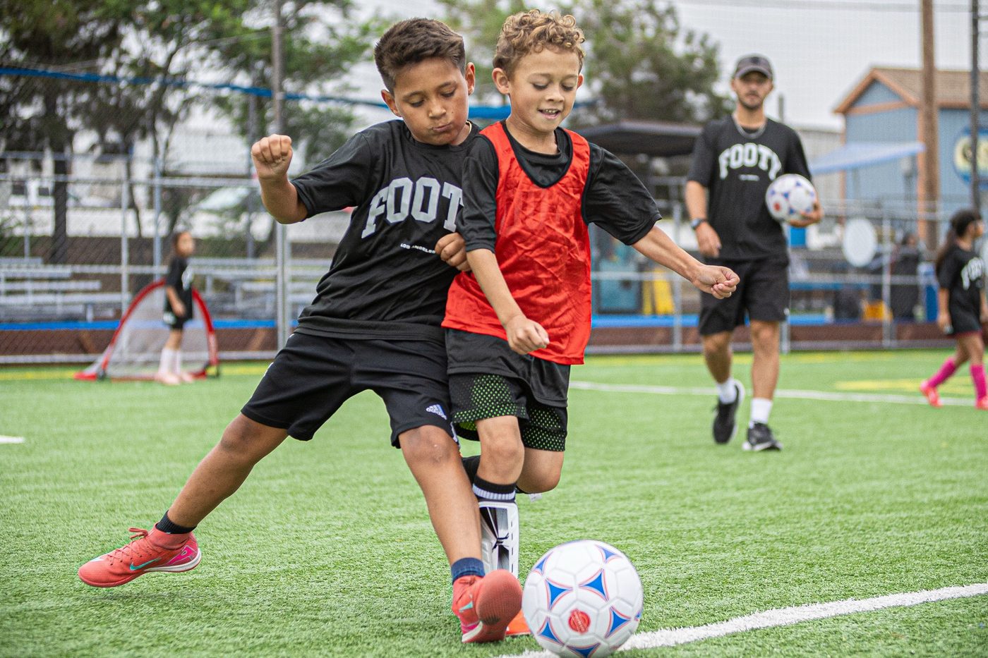 Two young players battling for the ball on the turf